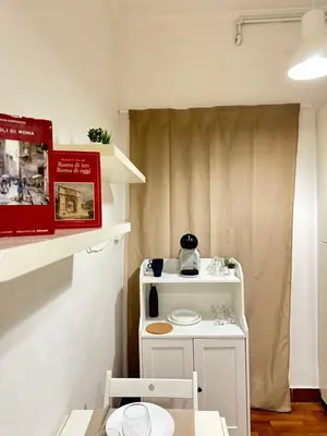 a small room with a table and a small kitchen at 1512 Apartment in Rome