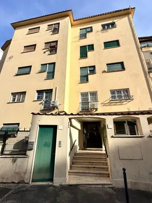 a tall building with a green door and stairs at 1512 Apartment in Rome