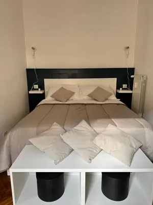 a white bed with pillows on top of it at 1512 Apartment in Rome