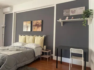 a bedroom with a bed and a table with a chair at CORNELIUS in Rome