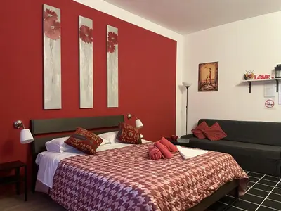 a bedroom with a bed with a red wall at CORNELIUS in Rome
