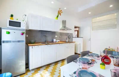 a kitchen with white cabinets and a white refrigerator at Appartamento via Milizia in Rome