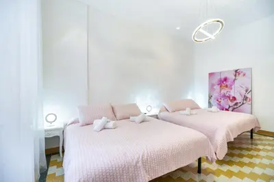 two beds in a room with pink and white at Appartamento via Milizia in Rome