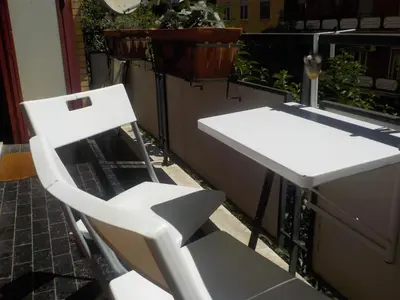a white chair sitting next to a sink on a balcony at Jack's House - Tourist Rentals - in Rome