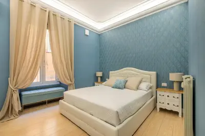 a blue bedroom with a bed and a window at Grande e storico appartamento ai Musei Vaticani in Rome