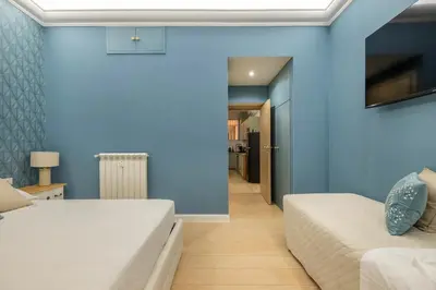 a bedroom with two beds and a blue wall at Grande e storico appartamento ai Musei Vaticani in Rome