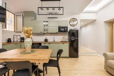 a kitchen and dining room with a table and a refrigerator at Grande e storico appartamento ai Musei Vaticani in Rome
