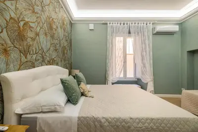 a bedroom with a bed and a couch and a window at Grande e storico appartamento ai Musei Vaticani in Rome