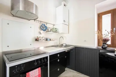 a kitchen with black and white cabinets and a sink at Imperial Forums Apartment IN Campitelli in Rome