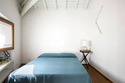 a bedroom with a bed in a white room at Imperial Forums Apartment IN Campitelli in Rome