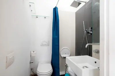 a bathroom with a white toilet and a sink at Imperial Forums Apartment IN Campitelli in Rome