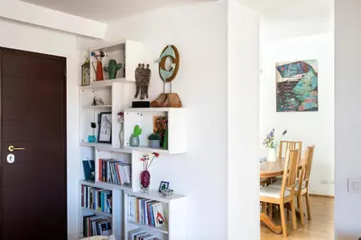 a room with a white book shelf filled with books at Imperial Forums Apartment IN Campitelli in Rome