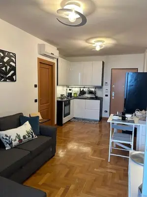a living room with a couch and a kitchen at Miro Home in Rome