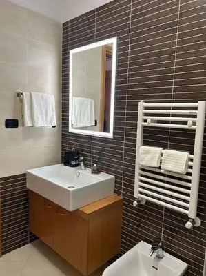 a bathroom with a sink and a mirror and a toilet at Miro Home in Rome