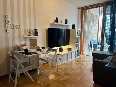 a living room with a table with chairs and a television at Miro Home in Rome