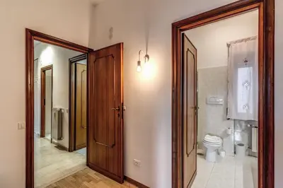 a bathroom with a toilet and a wooden door at Bellavista - Family&Friends big House-Saint Peter in Rome