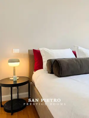 a bedroom with a bed and a side table at San Pietro Prestige Rooms in Rome