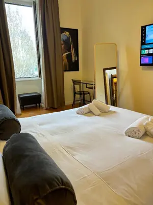a bedroom with two beds and a large window at San Pietro Prestige Rooms in Rome