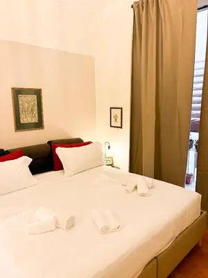 a large white bed with two white towels on it at San Pietro Prestige Rooms in Rome