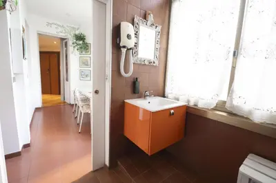 a bathroom with a white sink and a window at Trastevere 2 BR Cozy Apartment in Rome