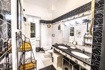 a bathroom with two sinks and a toilet at Trastevere 2 BR Cozy Apartment in Rome