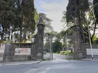 a gate to a park with graffiti on it at Trastevere 2 BR Cozy Apartment in Rome