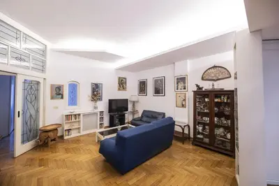a living room with a blue couch and a tv at Trastevere 2 BR Cozy Apartment in Rome