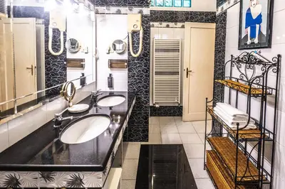 a bathroom with two sinks and a large mirror at Trastevere 2 BR Cozy Apartment in Rome