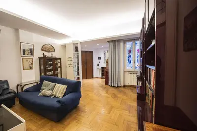 a living room with a blue couch and a tv at Trastevere 2 BR Cozy Apartment in Rome