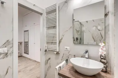a bathroom with a white sink and a mirror at Flaminio Royal Apartment in Rome