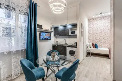 a living room with a glass table and blue chairs at Flaminio Royal Apartment in Rome