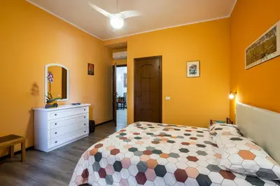 a bedroom with yellow walls and a bed and a dresser at My Vatican Home in Rome in Rome