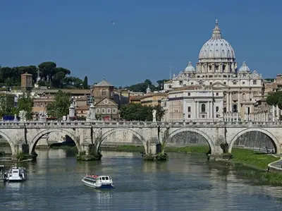 a bridge over a river with two boats on it at My Vatican Home in Rome in Rome