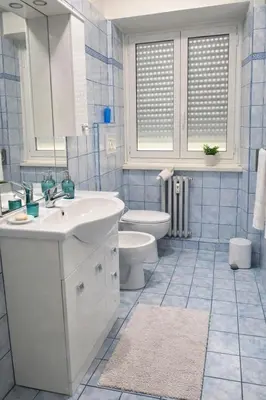 a blue tiled bathroom with a sink and a toilet at CASA DEL SOLE in Rome
