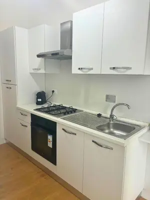 a white kitchen with a sink and a stove at CASA DEL SOLE in Rome