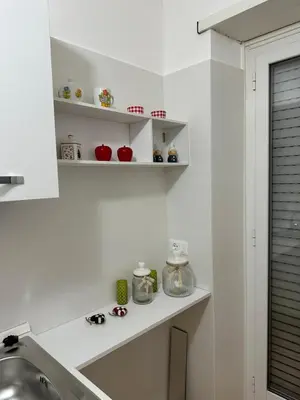 a kitchen with white shelves and a sink at CASA DEL SOLE in Rome