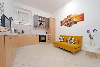 a living room with a yellow couch in a kitchen at Roma & Amor Apartment in Rome