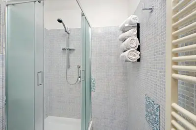 a bathroom with a shower with a glass door at Roma & Amor Apartment in Rome