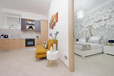 a bedroom with a bed and a yellow chair at Roma & Amor Apartment in Rome