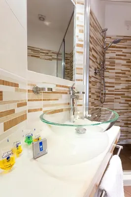 a bathroom with a glass sink and a mirror at B&B Sol Romae in Rome