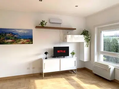 a living room with a tv and a window at Aurelia House Garden in Rome