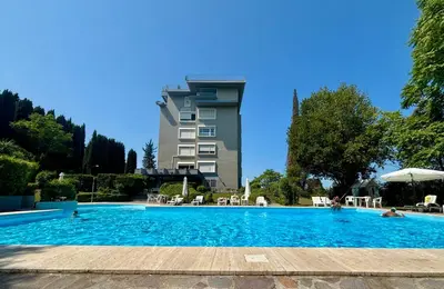 a large swimming pool with a building in the background at Aurelia House Garden in Rome