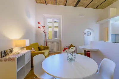 a kitchen and living room with a table and chairs at CasaLu San Pietro in Rome