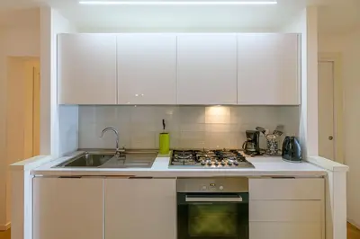 a kitchen with white cabinets and a stove top oven at CasaLu San Pietro in Rome