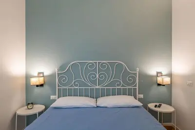 a bedroom with a blue bed with two tables at CasaLu San Pietro in Rome