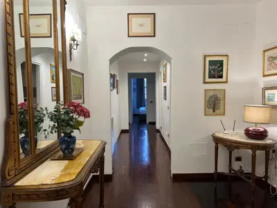 a hallway with a mirror and a table with flowers on it at Stunning Center Rome Apartment in Rome
