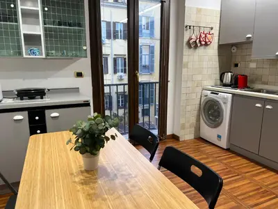 a kitchen with a table and a washing machine at Stunning Center Rome Apartment in Rome