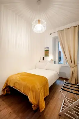 a bedroom with a large bed with a yellow blanket on it at DOMUS TRAIANA in Rome