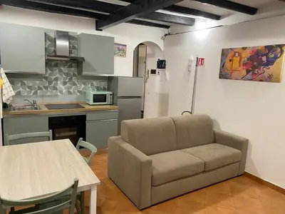 a living room with a couch and a kitchen at Casa Vicolo Moroni - Trastevere in Rome