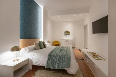 a bedroom with a large bed and a tv at Lifestyle Vatican Apartment in Rome
